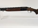 un fusil posé sur un socle transparent, sur fond blanc