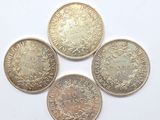 cinq pièces de monnaie britanniques différentes sur un fond blanc