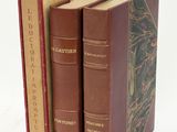 trois livres sont empilés sur une surface blanche