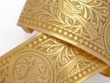 two gold bracelets on a white surface with a white background