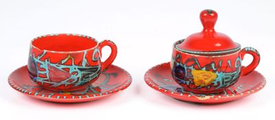 two cups and saucers sitting on a saucer