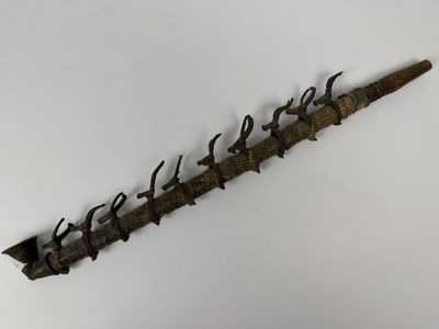 une image représentant un couteau très ancien et à l'aspect rouillé posé sur une surface blanche