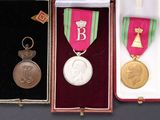 three medals and a medal in a case on a table
