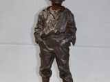 bronze statue of a man with a hat on a wooden base