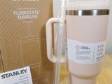 a pink coffee cup sitting on a table next to a cardboard box