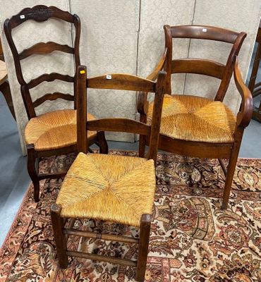 trois chaises et un tabouret sont posés sur un tapis dans une pièce