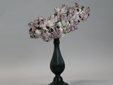 a black vase with a bunch of flowers in it