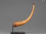 an elephant horn on a stand with a red dot on it ' s end