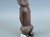 un gros plan sur une figurine représentant un oiseau, à laquelle est accrochée une étiquette