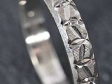 un gros plan d'une bague en argent sertie d'une pierre rouge