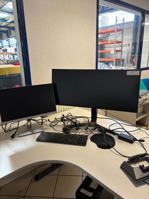 two computer monitors sitting on a desk with a keyboard and mouse