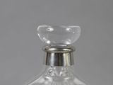 a clear glass bottle with a silver stopper on it