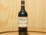 une bouteille de vin posée sur un tonneau
