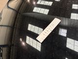 a sticker on the windshield of a car that is parked in a parking lot