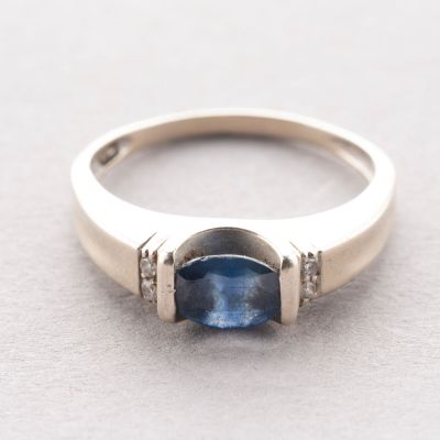 gros plan d'une bague avec un saphir bleu et des diamants