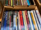 un grand nombre de dvd dans une boîte posée sur le sol