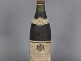 an old bottle of wine sitting on top of a table