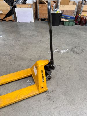a fork lifter sitting on the floor in a warehouse