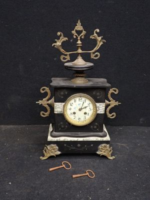 une horloge posée sur une table, à côté d'une paire de ciseaux