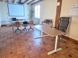 une salle équipée d'une table, de chaises et d'un écran de projection