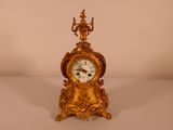 une horloge en or posée sur une table blanche
