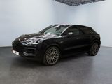 Une Porsche Cayenne noire est garée dans une grande pièce.