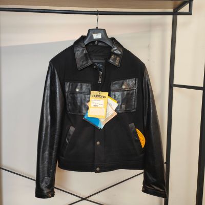 une veste en cuir noir accrochée à un porte-manteau dans une pièce