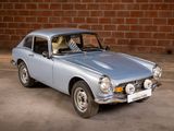 a small blue car parked in front of a brick wall