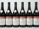 six bouteilles de vin rouge sont alignées sur une table