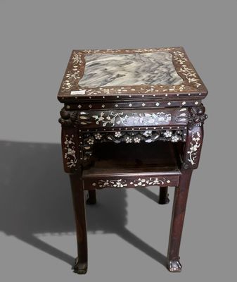 a small table with a marble top on a gray background