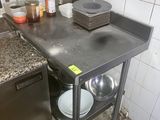 une cuisine équipée d'un évier, d'une cuisinière, d'un lave-vaisselle et d'autres éléments posés sur le plan de travail