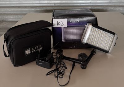 une image représentant un appareil photo, un flash et d'autres objets posés sur une table