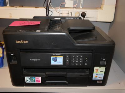 a printer that is sitting on a desk next to a window