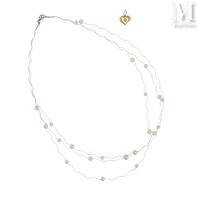 collier avec des perles et un pendentif en forme de cœur en or sur fond blanc