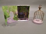 a small birdcage and a picture frame with a picture on it