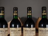 three bottles of red wine are lined up on a table