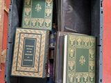 de nombreux livres dans une boîte noire posée par terre