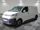 la camionnette blanche est garée dans une grande pièce au sol en damier