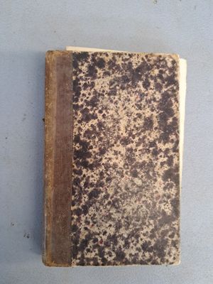 un vieux livre posé sur une table blanche
