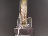 gold and diamond bangle bracelet on display on a clear acrylic stand