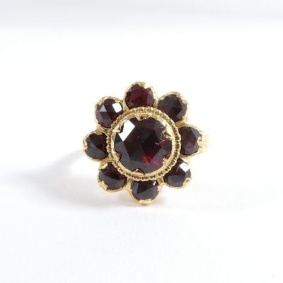 une image représentant une bague en or sertie de grenats