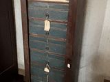 une grande armoire en bois comportant plusieurs tiroirs et des étiquettes