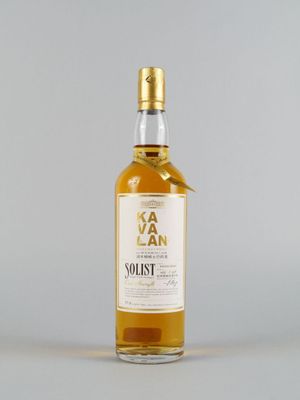 une bouteille de whisky posée sur une surface blanche, avec un fond gris