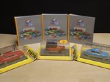 three boxed toy cars are sitting on a table in front of a black background