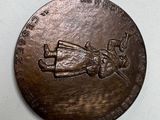 a bronze medal with a picture of a person on it