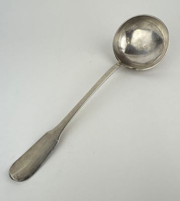 une cuillère en argent avec un manche de cuillère sur une surface blanche