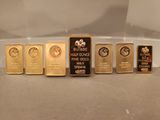 cinq lingots d'or sont alignés sur une table
