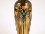 un vase doré orné de fleurs sur fond blanc