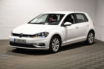 La Volkswagen Golf blanche est garée dans une pièce blanche.
