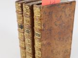 plusieurs vieux livres sont empilés sur une surface blanche